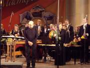 Композитор Михаил Броннер, дирижер Галина Перевозникова и ее оркестр принимают цветы и аплодисменты.